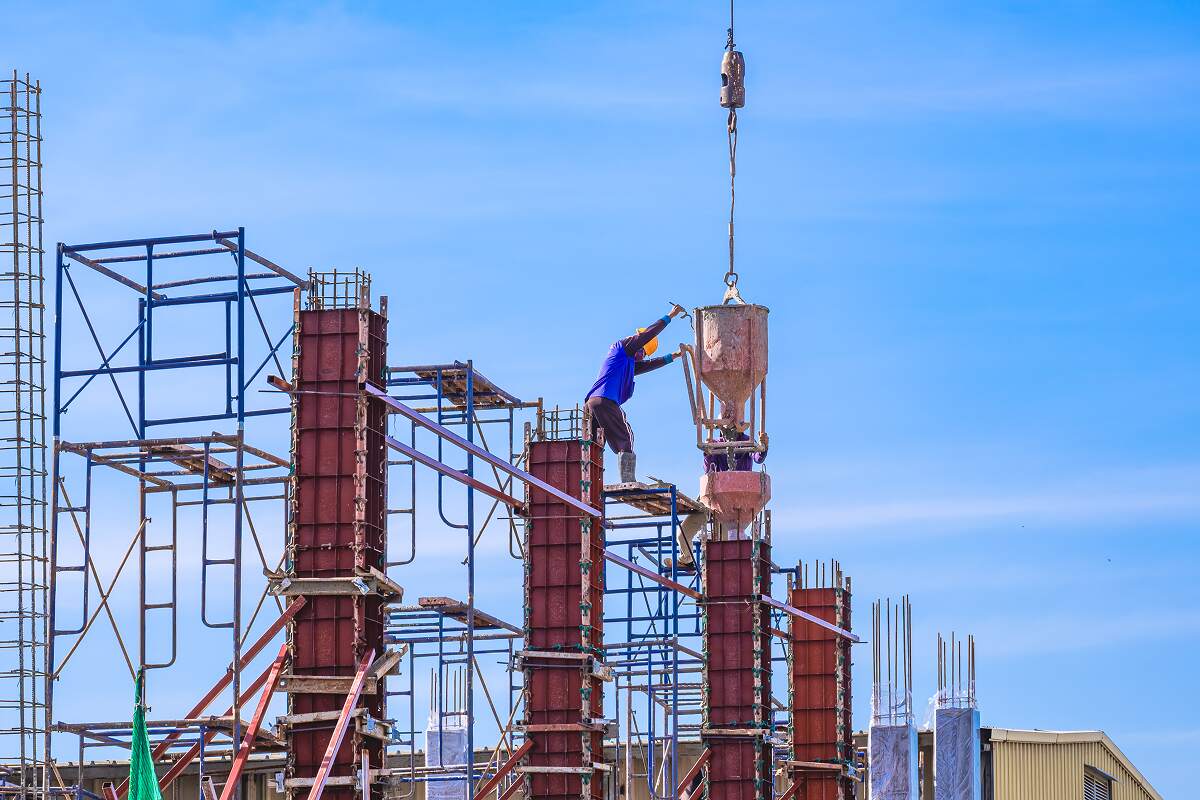 Proyek 4 2 construction workers on scaffolding are pouring XFKEMYB